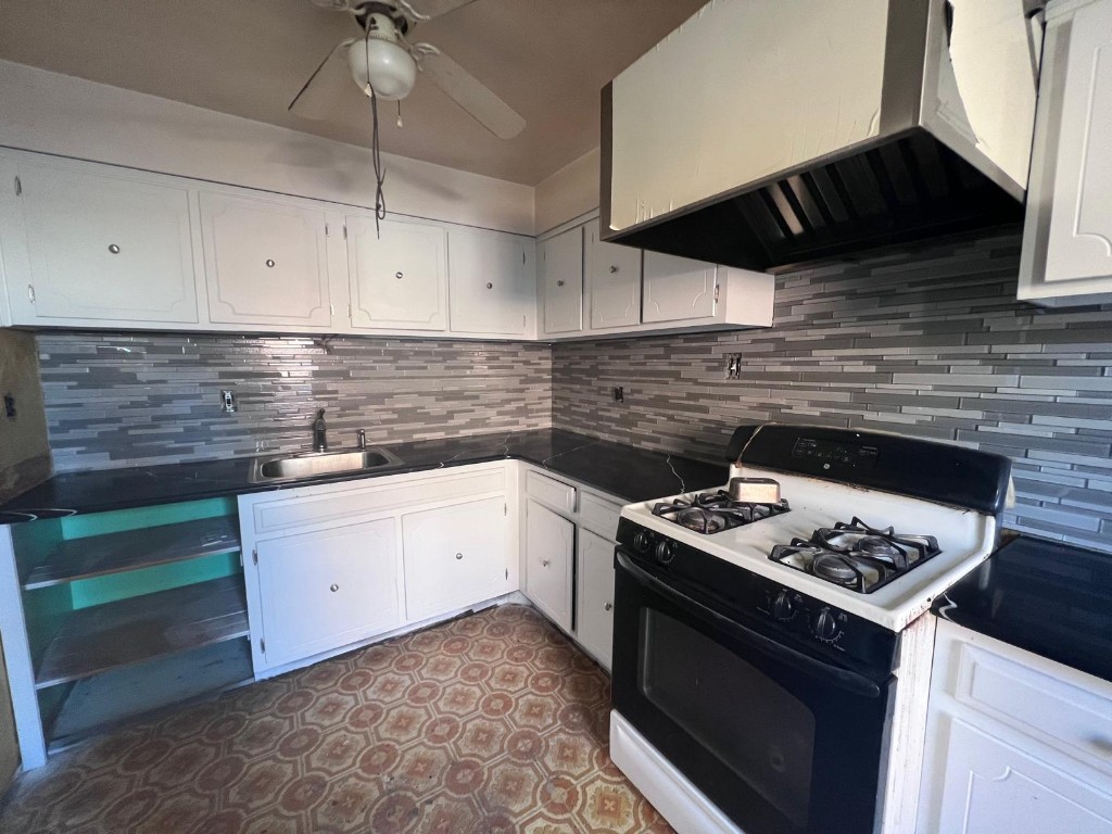 Kitchen project — white cabinetry, dark countertops, and grey backsplash